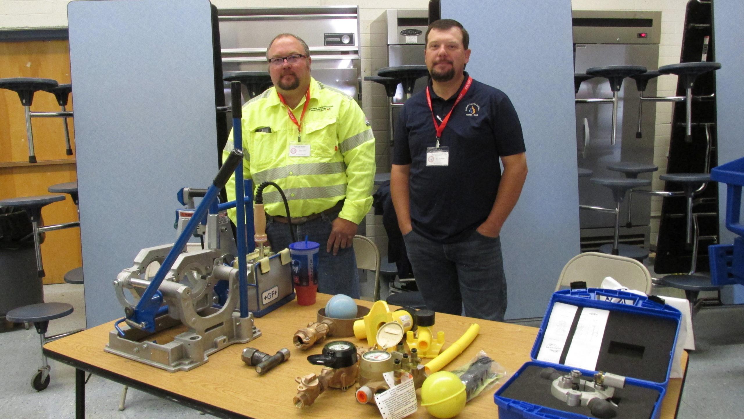 2 GCEC members with the table of prizes at the 2019 annual meeting