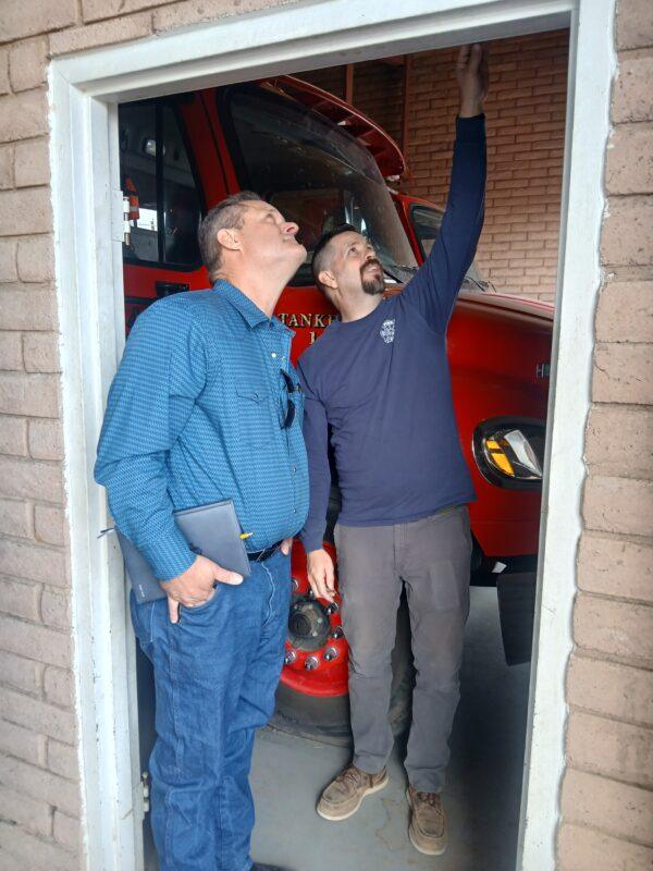 Two men inspect firehouse entryway